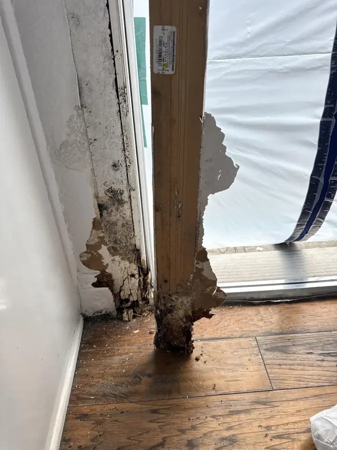 A corroded pipe leak traced at the wall base